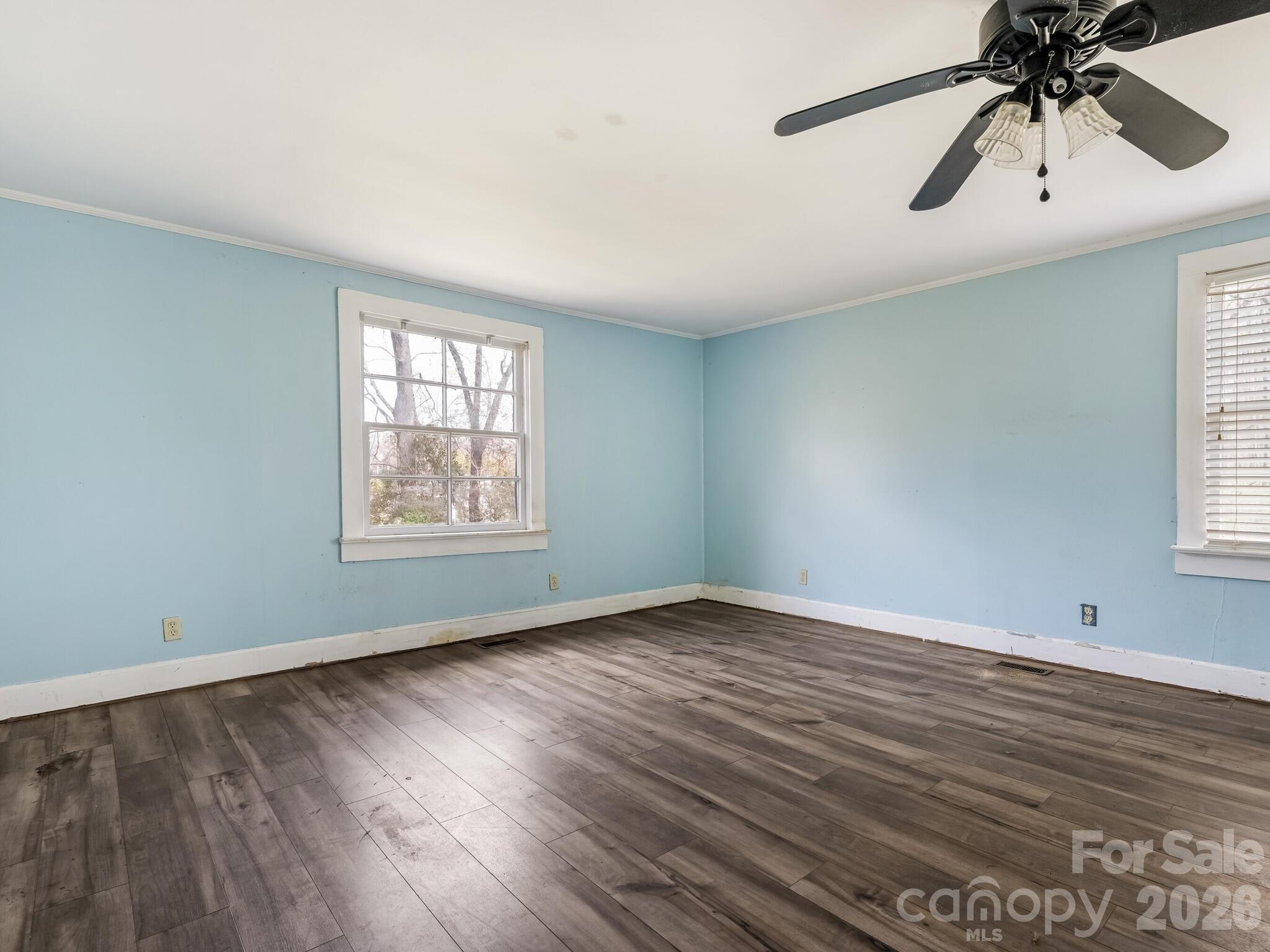2346 Sam Newell Road Matthews, NC 28105 - Photo 7 of 18 an empty room with wooden floor chandelier fan and windows