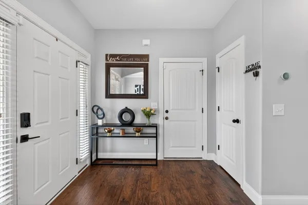 a view of a hallway with entryway wooden floor and front door
