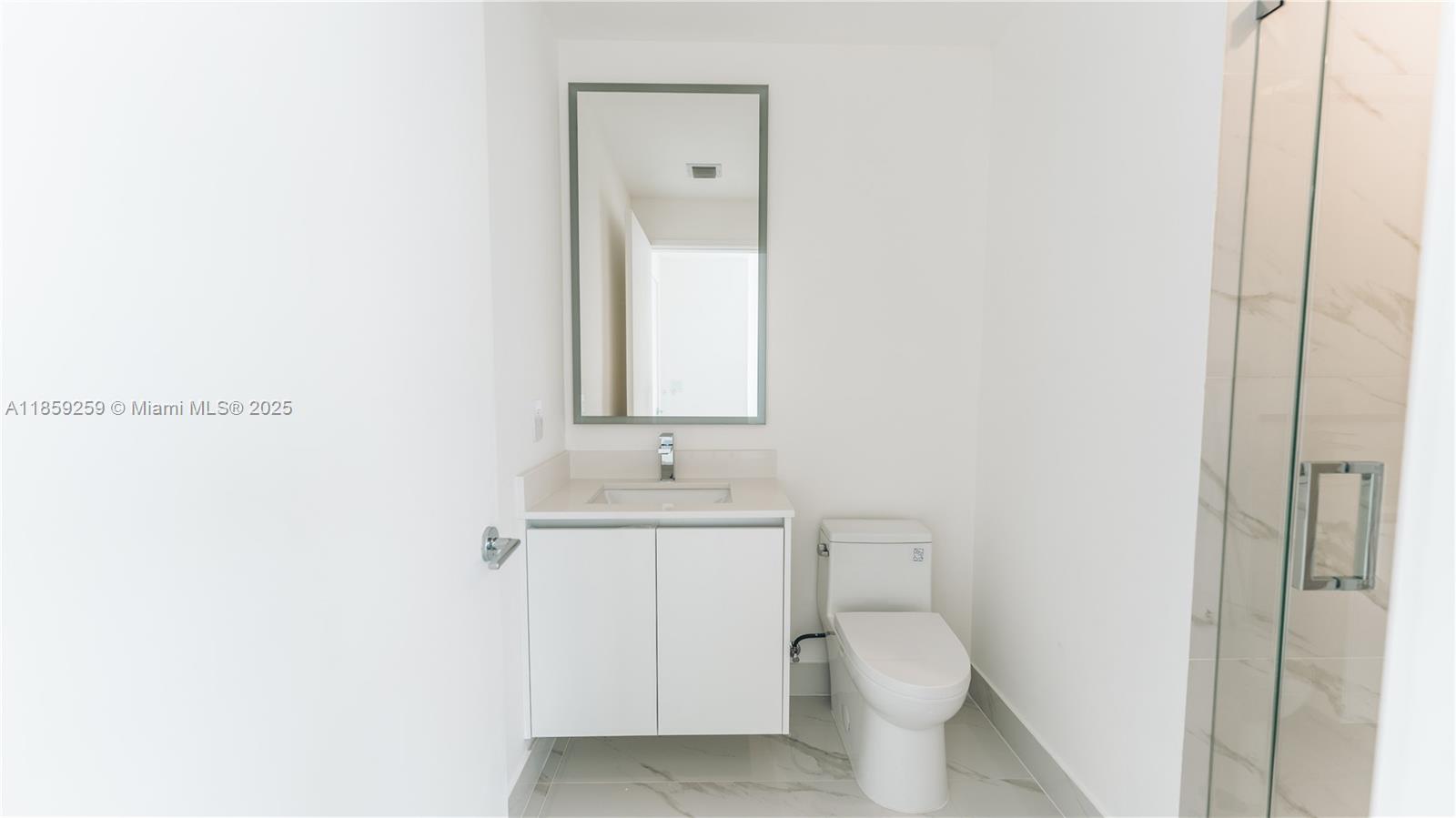700 Northeast 24th Street, Unit 4407 Miami, FL 33137 - Photo 45 of 75 a bathroom with a toilet a sink a vanity and mirror
