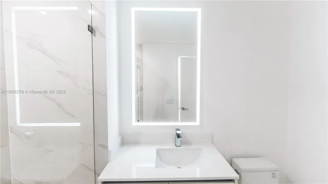 a bathroom with a sink a toilet and mirror