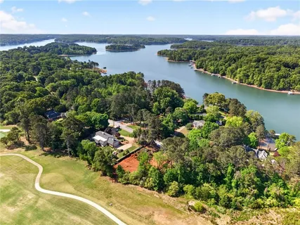an aerial view of residential houses with outdoor space and lake view