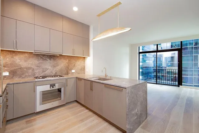 a kitchen with stainless steel appliances granite countertop a stove a sink and a microwave