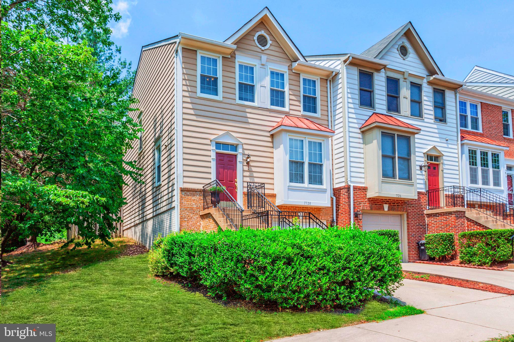 a front view of a house with a yard and potted plants