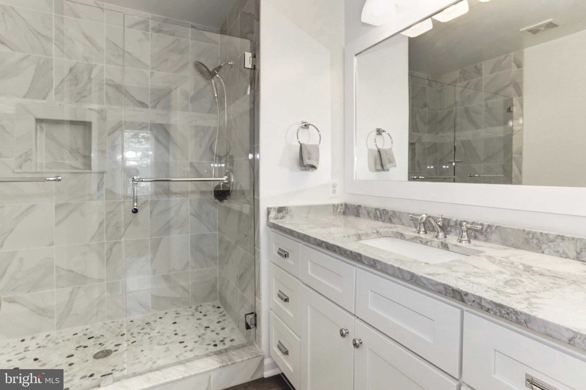 7728 Hickory Glen Way Springfield, VA 22153 - Photo 16 of 26 a bathroom with a granite countertop sink a mirror and shower