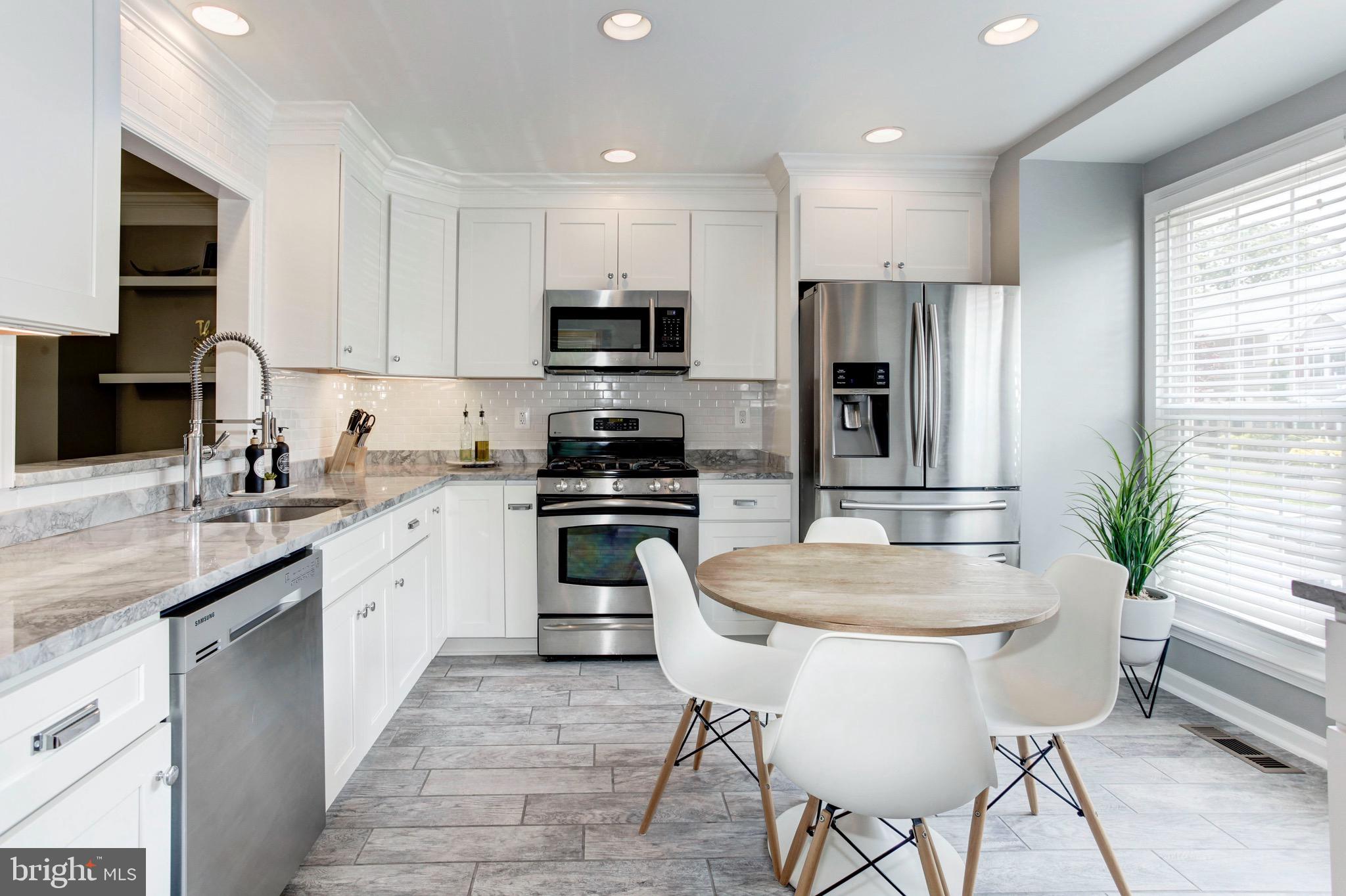 7728 Hickory Glen Way Springfield, VA 22153 - Photo 4 of 26 a kitchen with stainless steel appliances granite countertop a stove a sink a microwave a refrigerator and cabinets