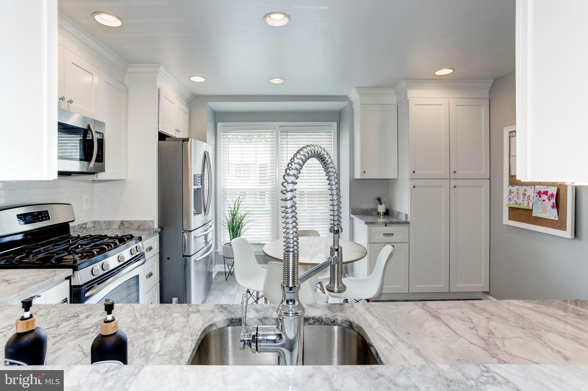 7728 Hickory Glen Way Springfield, VA 22153 - Photo 6 of 26 a kitchen with stainless steel appliances kitchen island granite countertop a refrigerator and a stove top oven