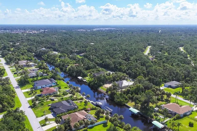 an aerial view of residential houses with outdoor space and trees