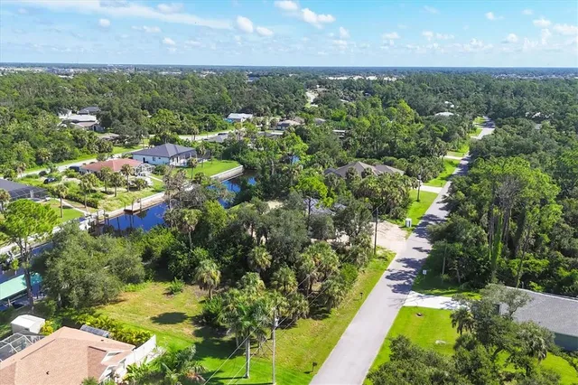 an aerial view of residential houses with outdoor space and trees