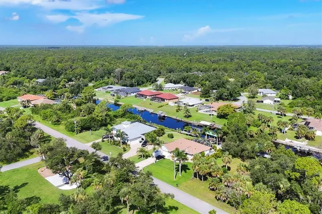 an aerial view of residential houses with outdoor space and trees