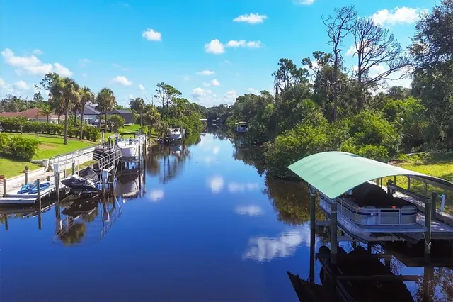 a view of a chairs and table in swimming pool next to a yard