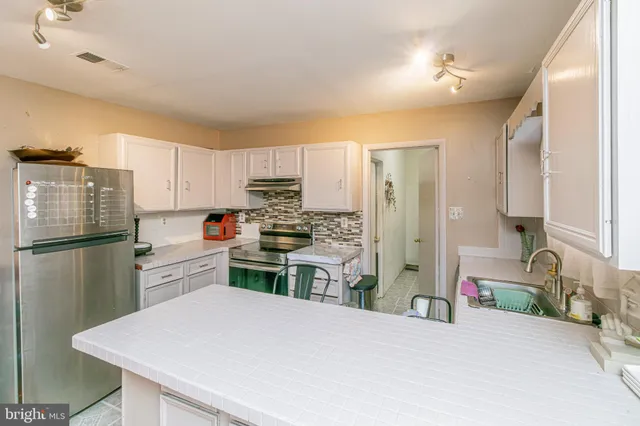 a kitchen with a refrigerator a stove and a sink