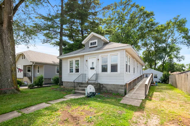 a front view of a house with a yard porch and outdoor seating