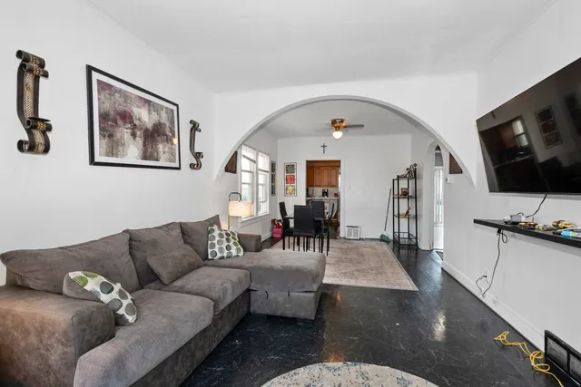 a living room with furniture a flat screen tv and kitchen view