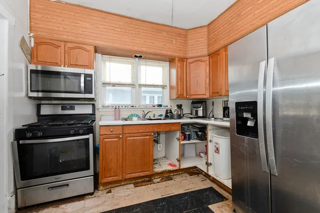 a kitchen with stainless steel appliances granite countertop a stove a refrigerator and a microwave