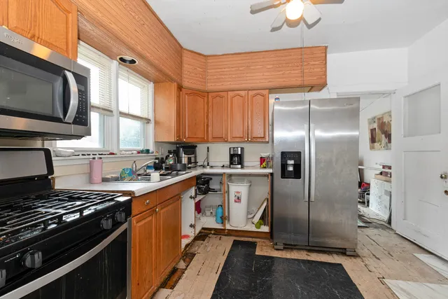 a kitchen with stainless steel appliances granite countertop a stove refrigerator and a microwave