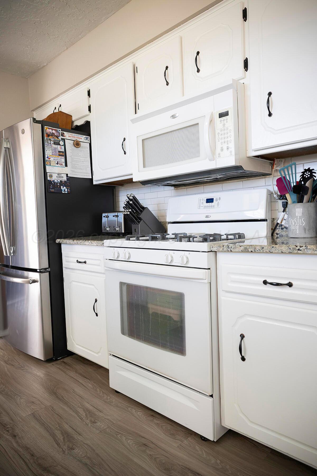 611 Floyd Avenue Dumas, TX 79029 - Photo 11 of 28 a kitchen with white cabinets and white appliances