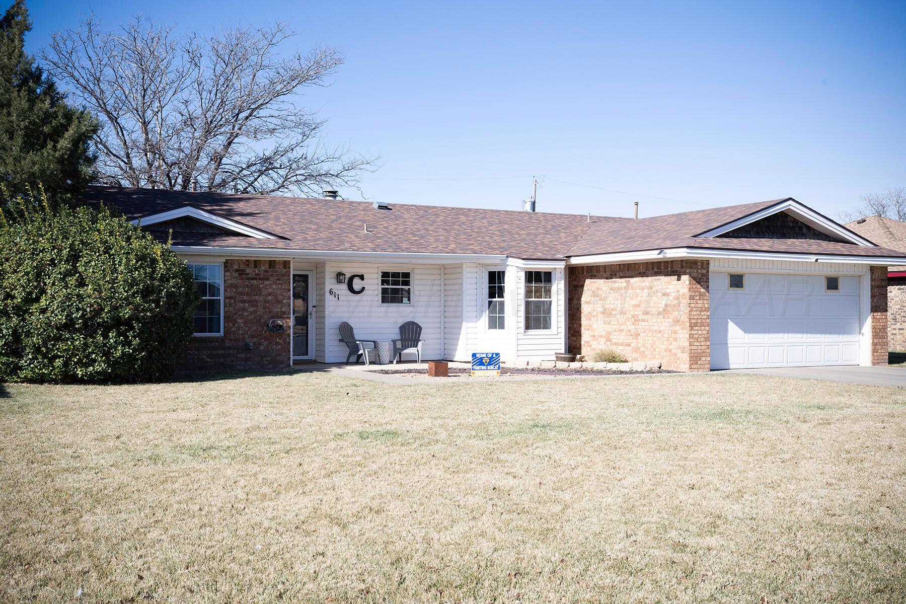 611 Floyd Avenue Dumas, TX 79029 - Photo 2 of 28 a front view of a house with a garden and trees