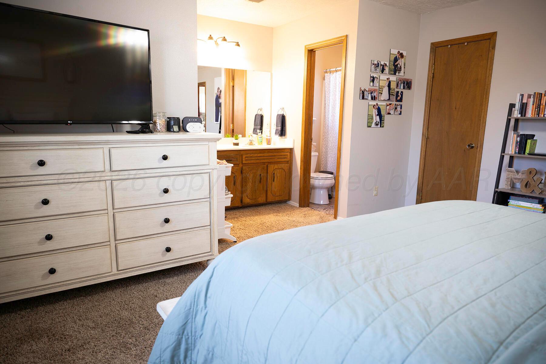 611 Floyd Avenue Dumas, TX 79029 - Photo 21 of 28 a bedroom with a bed and a flat screen tv