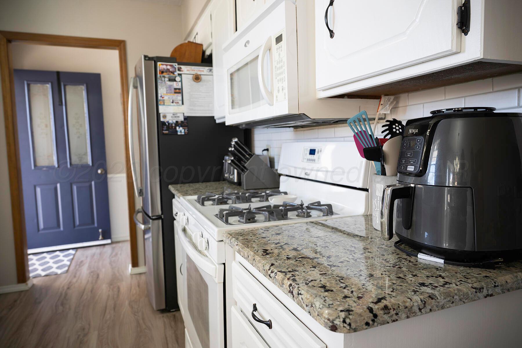 611 Floyd Avenue Dumas, TX 79029 - Photo 8 of 28 a kitchen with stainless steel appliances granite countertop a sink stove and refrigerator