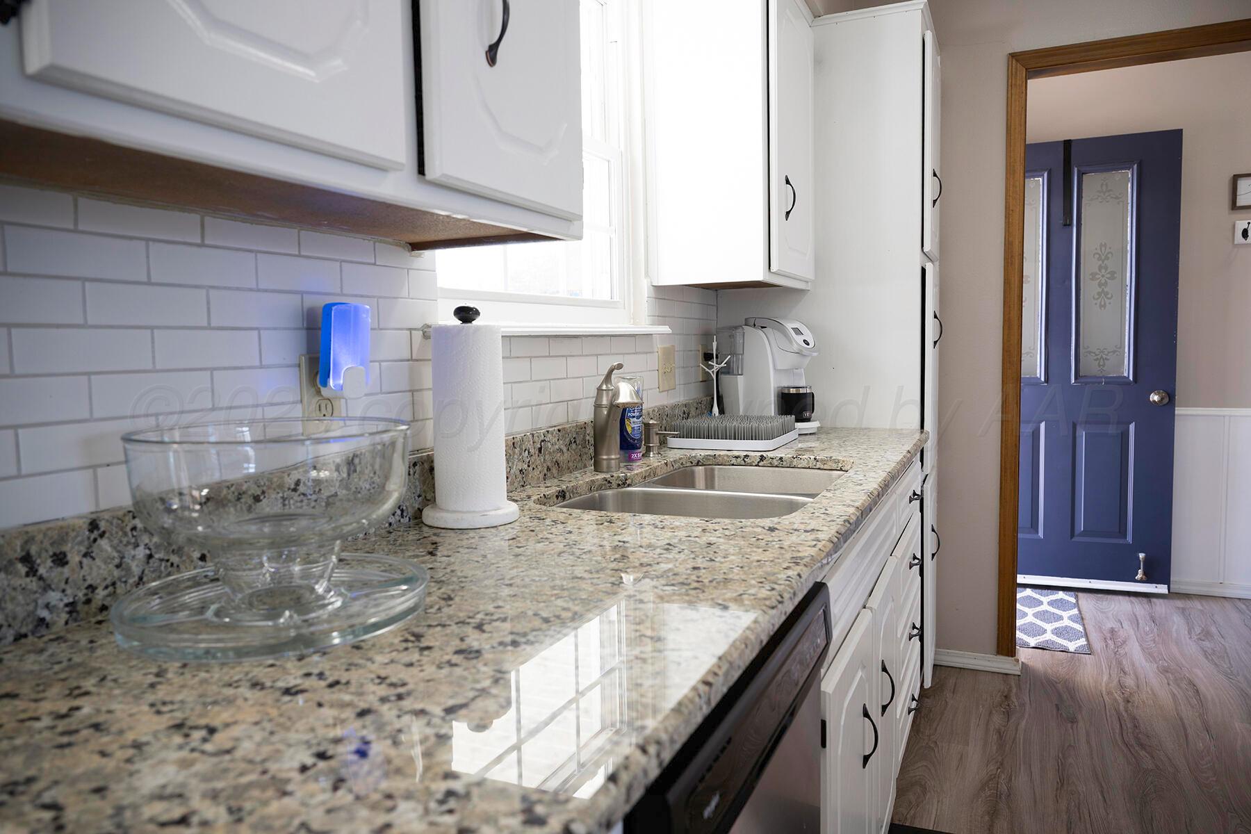 611 Floyd Avenue Dumas, TX 79029 - Photo 9 of 28 a kitchen with sink a stove and cabinets