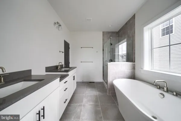 a spacious bathroom with a double vanity sink and a bathtub