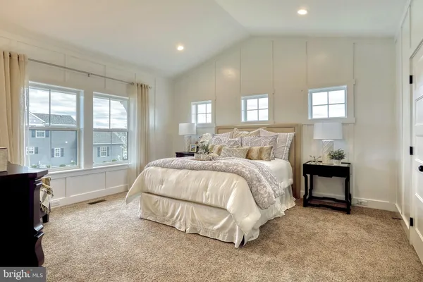 a spacious bedroom with a bed and a large window