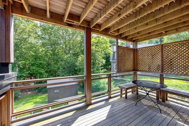 an aerial view of a residential houses with outdoor space and trees all around