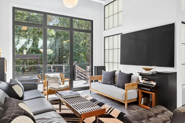 a living room with furniture and a floor to ceiling window