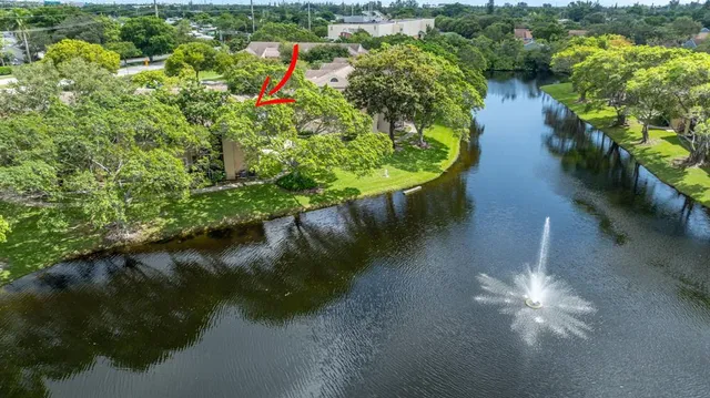 an aerial view of a house with a yard and lake view in back