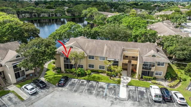 a view of a lake with a yard and a large tree