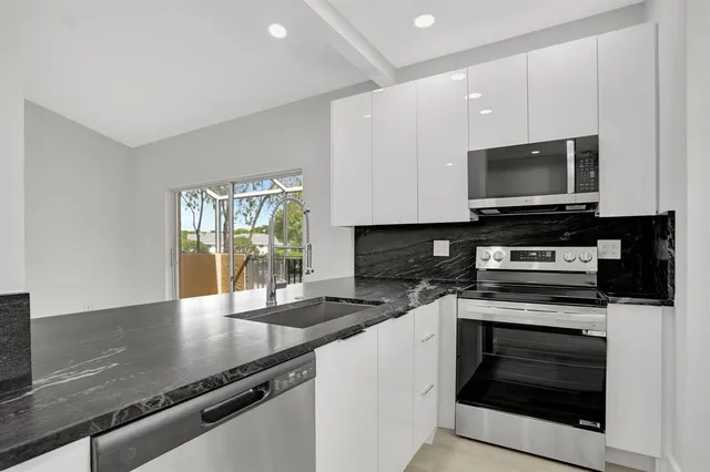 a kitchen with stainless steel appliances a stove microwave and cabinets