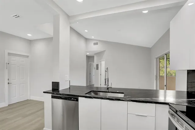 a kitchen with granite countertop a sink and cabinets
