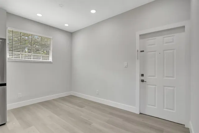 an empty room with wooden floor and window