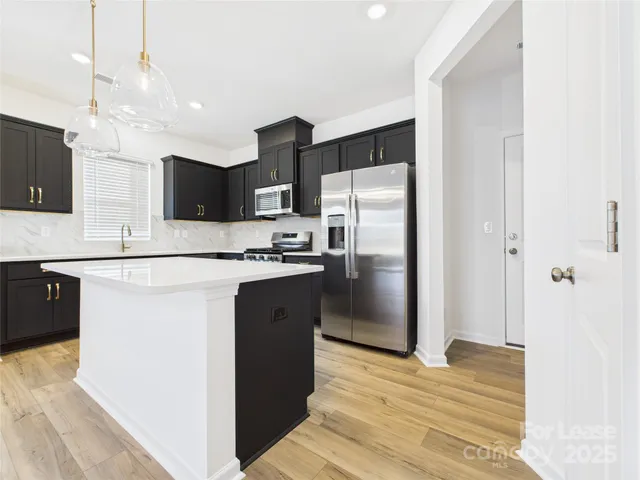 a kitchen with stainless steel appliances a refrigerator sink and microwave