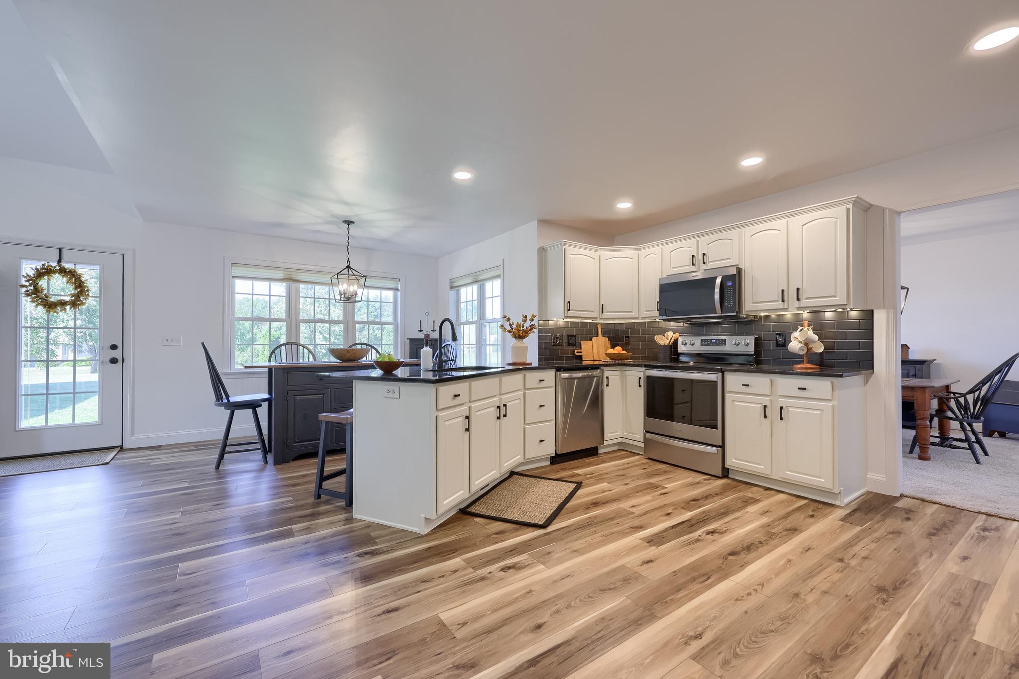 809 West Brubaker Valley Road Lititz, PA 17543 - Photo 10 of 58 a kitchen with a refrigerator and a dining table with wooden floor