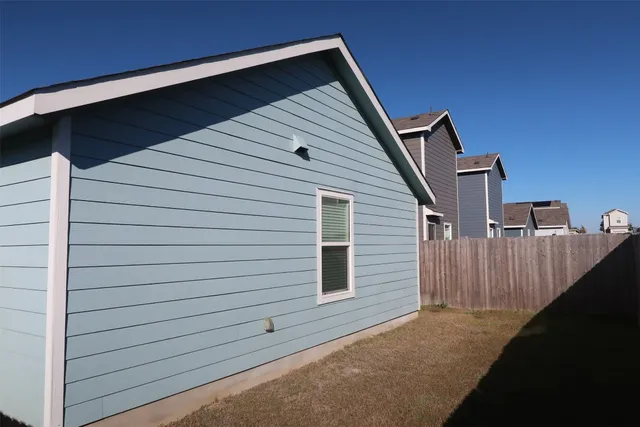 a view of a backyard with wooden fence