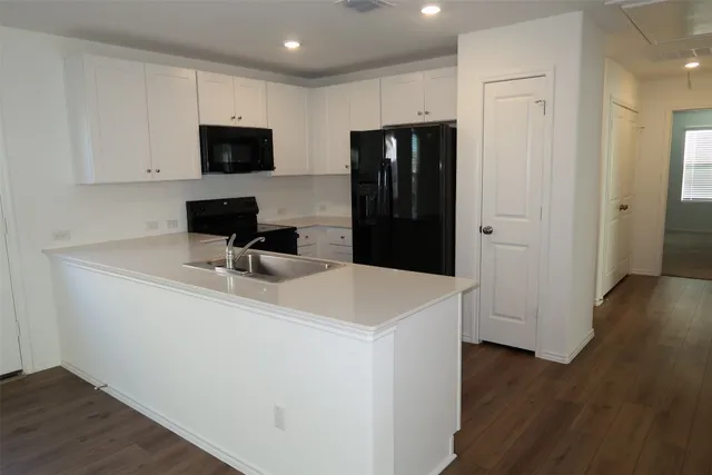 a view of a big room with wooden floor and windows