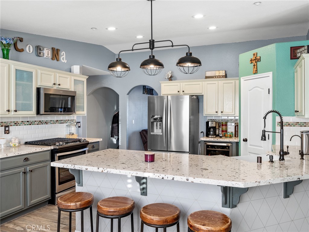 12326 Silver Rock Road Pinon Hills, CA 92372 - Photo 19 of 41 a kitchen with stainless steel appliances granite countertop a sink a stove top oven a dining table and chairs