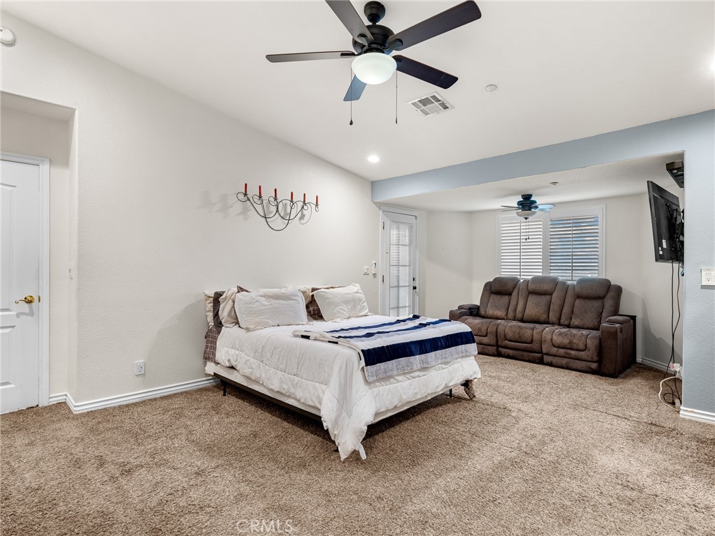 12326 Silver Rock Road Pinon Hills, CA 92372 - Photo 25 of 41 a spacious bedroom with a bed and ceiling fan