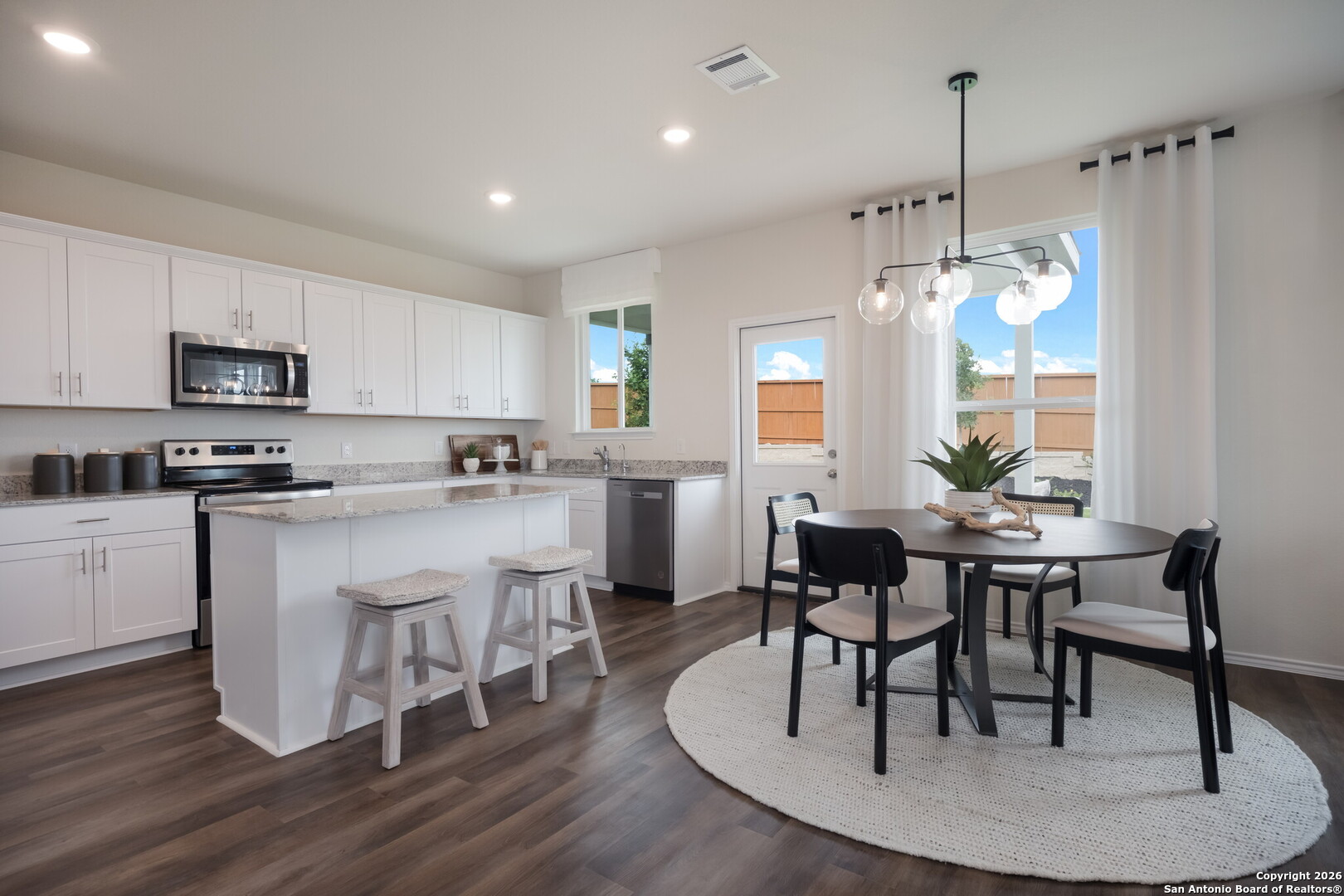 4059 Paddock Trail Seguin, TX 78155 - Photo 12 of 29 a kitchen with microwave a dining table and chairs