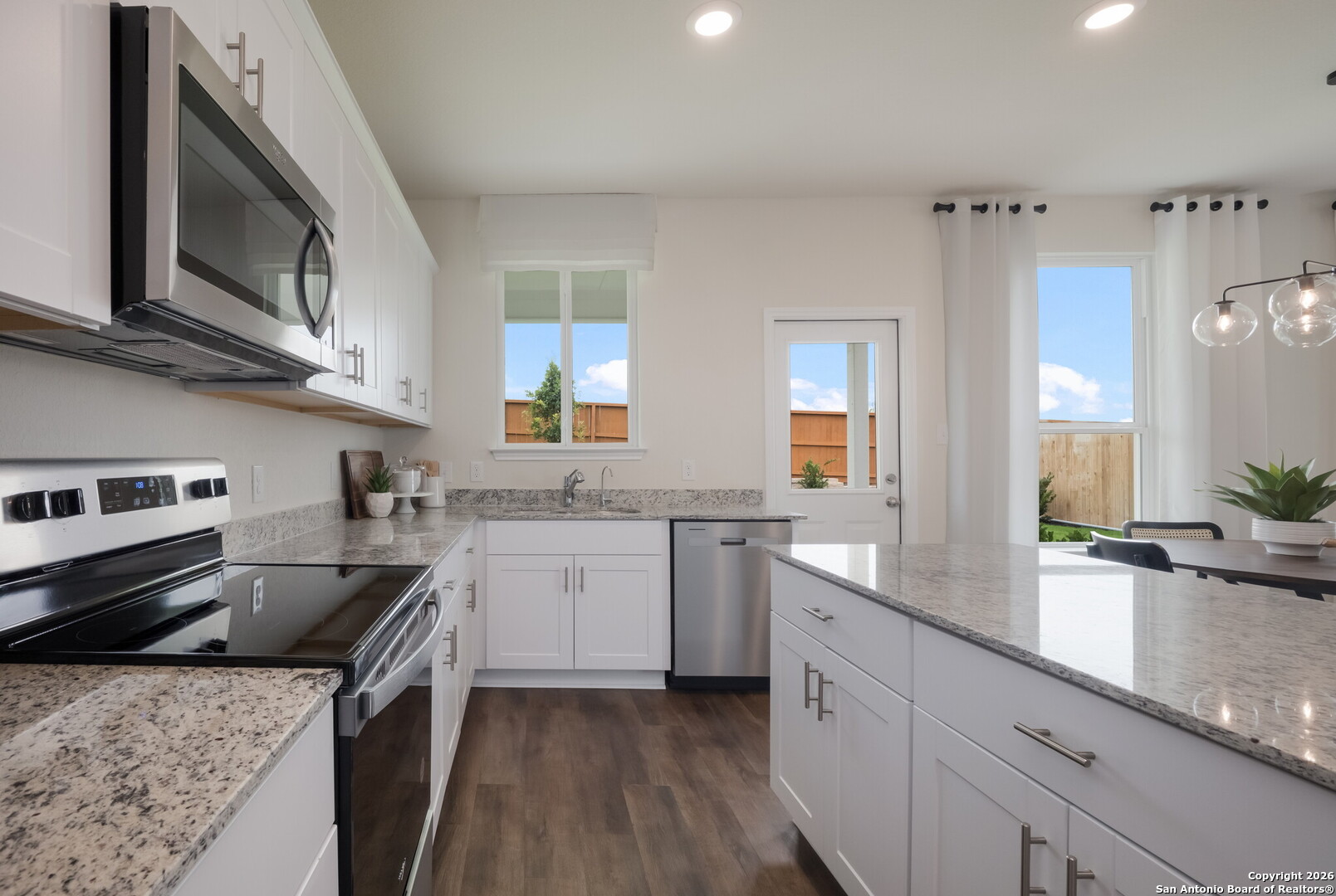 4059 Paddock Trail Seguin, TX 78155 - Photo 13 of 29 a kitchen with stainless steel appliances granite countertop a sink stove and cabinets