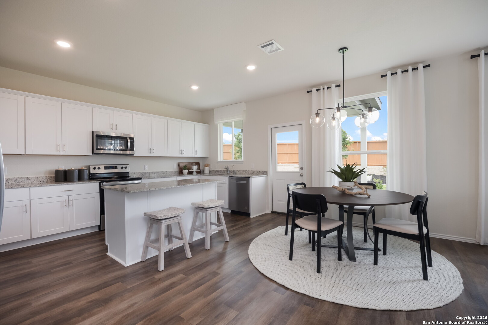 4059 Paddock Trail Seguin, TX 78155 - Photo 7 of 29 a kitchen with a table chairs a sink dishwasher stove and cabinets with wooden floor