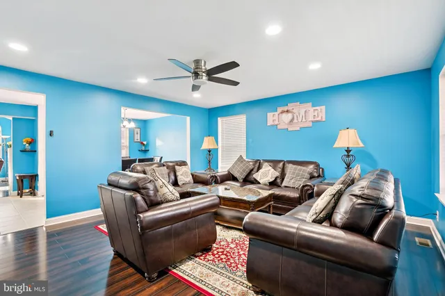 a living room with furniture and a wooden floor