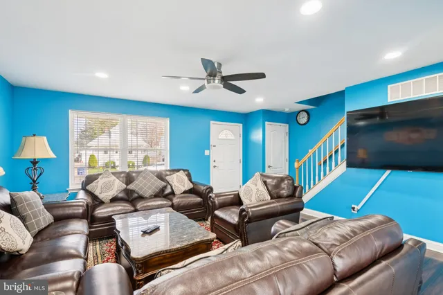 a living room with furniture ceiling fan and a flat screen tv
