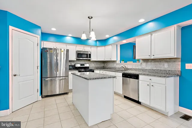 a kitchen with stainless steel appliances granite countertop a refrigerator sink and microwave