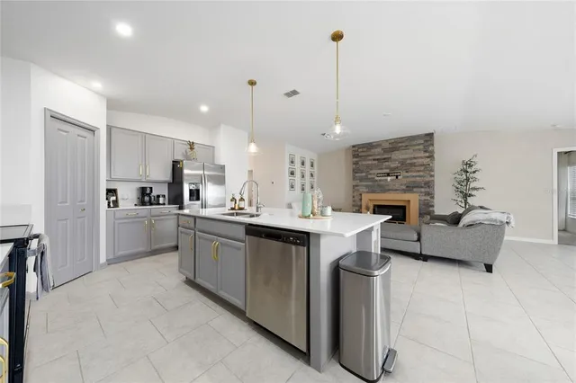a kitchen with kitchen island granite countertop a sink counter top space and stainless steel appliances