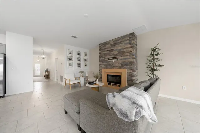 a living room with furniture a fireplace and a potted plant