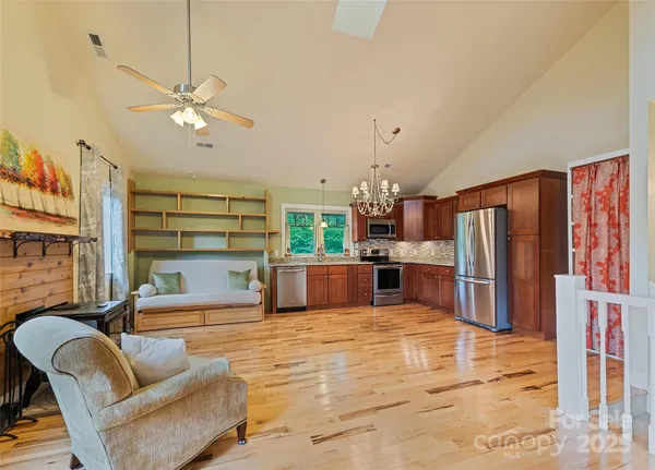 a kitchen with stainless steel appliances kitchen island granite countertop a refrigerator a stove a microwave oven with a dining table and chairs