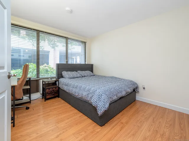 a bedroom with a bed a table and a window