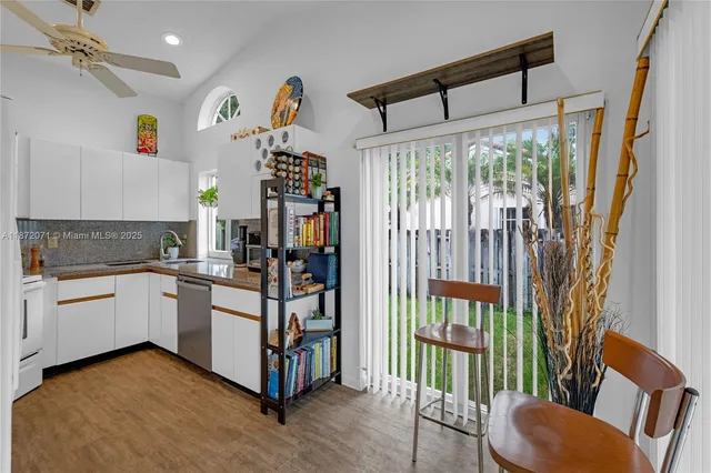 a kitchen with stainless steel appliances granite countertop a refrigerator a stove and a wooden floors